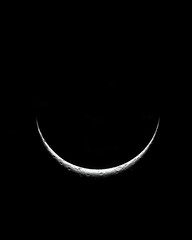 Beautiful Crescent Moon Glowing in the Night Sky with a Dark Background, Detail of Surface Craters and Texture Visible, Captivating Celestial Image
