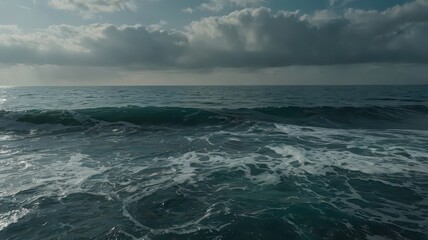 Fototapeta premium Powerful ocean wave crashes near rocky shore under bright sky