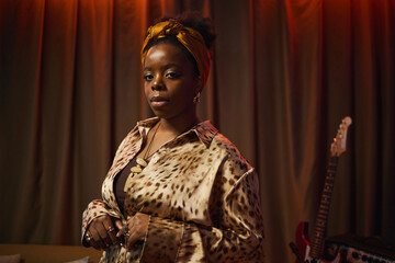 Portrait of African American woman in elegant clothes standing in studio