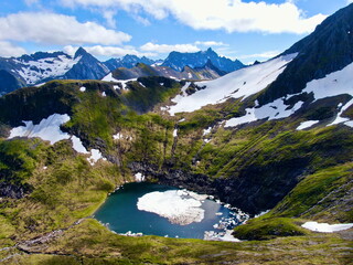 Aerial view of Aavatnet lake in the Aarskog Valley near Vartdal, Norway. The lake is partially covered with ice even though it is mid-summer (July)