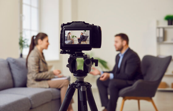 Digital camera filming equipment, showing skilled smart blogger man sharing knowledge, recording educational seminar, webinar, training, prof lecture or job interview to female vlogger, journalist