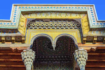 Decorated wooden iwan of Bolohovuz Mosque in Bukhara, showing detailed arches, columns, and...