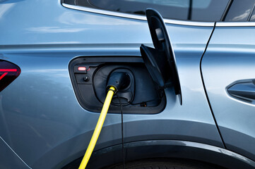 use an electric charging station for charging modern electric car. Concept of economic charging and...