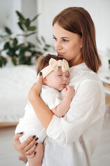 mom puts the baby to sleep by rocking him, mom holds the baby in her arms gently hugging and kissing him, mother and child, healthy sleep of the child with the mother