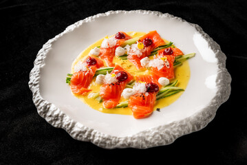 Vibrant dish featuring thinly sliced salmon atop a bed of vegetables, adorned with cream and garnishes, elegantly presented on a textured white plate, perfect for fine dining and gourmet showcases.