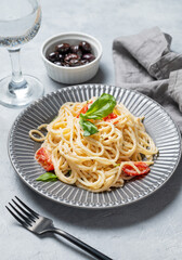 Creamy spaghetti with cherry tomatoes, parmesan cheese and basil on a plate