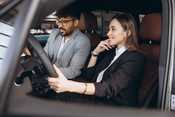 Managers testing new car in car dealership showroom