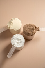 Chocolate, vanilla protein powder in scoops. Food supplement, fitness sport, health and nutrition.