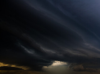 Large black clouds in the sunset sky before the rain