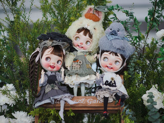 Cute dolls. Three happy girl group dressed in animal theme including rabbit and duck. Vintage dolls are on display at the doll weekend market fair. Soft focus on the left girl's right eye.
