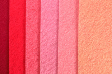 Different shades of pink felt folded vertically on top of each other. From dark pink to light pink.