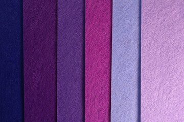 Fototapeta premium Different shades of purple felt folded vertically on top of each other. Dark and light purple felt color palette.