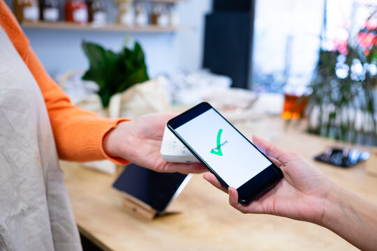 Customer making contactless payment using mobile phone in grocery store