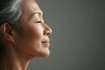 Peaceful Profile of Mature Woman with Eyes Closed Capturing Calmness.