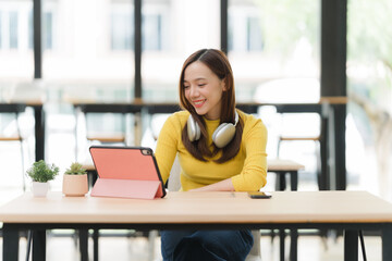 Smiling Woman Using Tablet at Desk