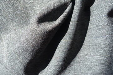 Soft folds on salt and pepper polyester fabric