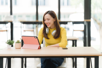 Obraz premium Smiling Woman Using Tablet at Desk