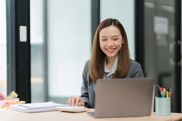Smiling Asian Businesswoman Working at Desk