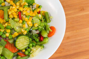 Boiled mixture of different vegetables, fragment top view close-up