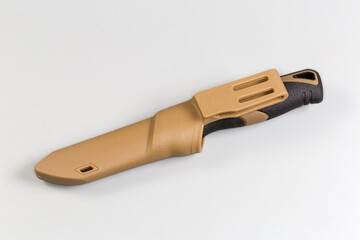 Fixed tourist knife in plastic sheath on a gray background