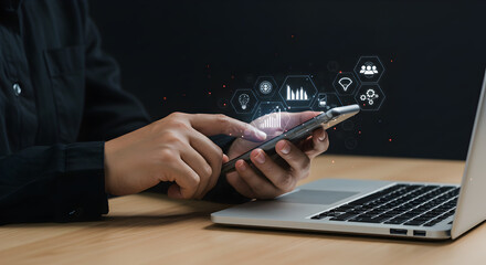 Businessman Analyzing Digital Data on Smartphone Near Laptop with Black Background