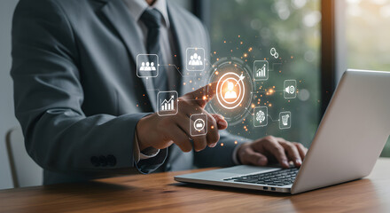 Businessman Interacting with Virtual Network Using Laptop on Wooden Desk in Office Environment with Natural Lighting