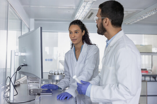 Focused scientists colorating at oratory workstation