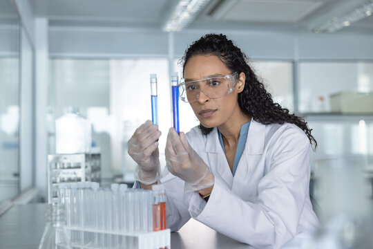 Scientist comparing two test tubes with liquids