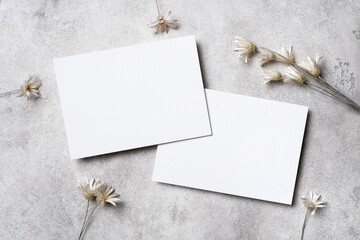 Two blank wedding invitation cards mockup with dried flowers, white paper cards front and back...