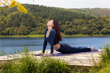 Redhead girl doing sports in nature. Girl doing yoga in nature.