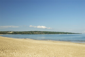 Fototapeta premium Tranquil coastal landscape of bali beach with clear blue sea and sky
