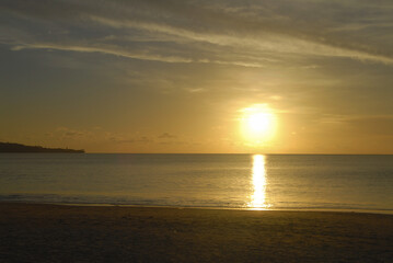 Serene bali sunset on tranquil beach with golden sky reflections