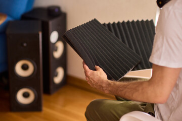 Setting up audio equipment with soundproofing panels in a modern studio environment