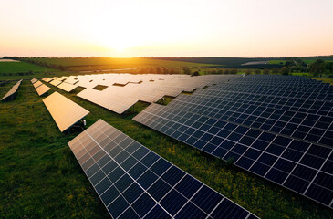 Aerial view of a solar farm generating solar energy.Solar panels park generating green energy electric at sunset.Green energy reduce carbon emissions and makes earth cleaner and more ecological.	
