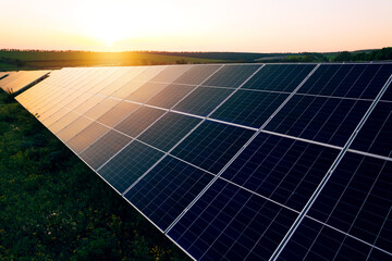 Aerial view of a solar farm generating solar energy.Solar panels park generating green energy electric at sunset.Green energy reduce carbon emissions and makes earth cleaner and more ecological.	
