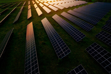 Aerial view of a solar farm generating solar energy.Solar panels park generating green energy electric at sunset.Green energy reduce carbon emissions and makes earth cleaner and more ecological.	
