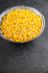 Macaroni pasta raw coquillette appetizer dish organic product fresh tasty gourmet food background on the table rustic food top view copy space