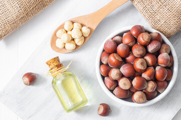Hazelnut oil, filbert and cooking oil in glass bottle on white wooden table, heap or stack of...