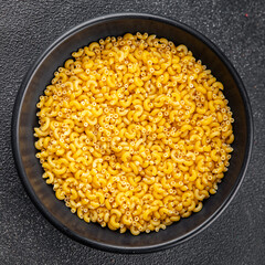 Macaroni pasta raw coquillette appetizer dish organic product fresh tasty gourmet food background on the table rustic food top view copy space