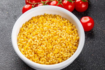 Macaroni pasta raw coquillette appetizer dish organic product fresh tasty gourmet food background on the table rustic food top view copy space