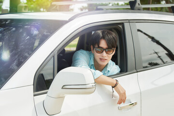 Fototapeta premium Young Asian Man Driving Car with Arm Out Window