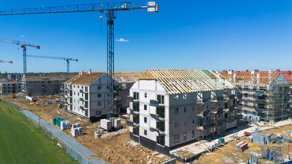 Fototapeta premium Aerial view of a residential construction site with cranes and unfinished buildings