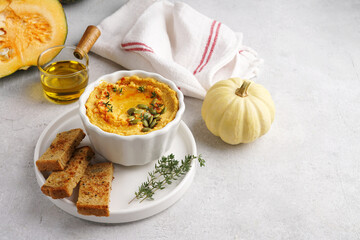 Pumpkin hummus with olive oil and sticks of bread and white pumpkin on white napkin, copy space