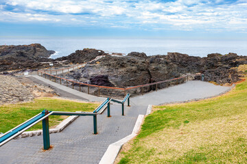 Steps leading down to Kiama blowhole outside the town of Kiama, NSW. Australia. Popular blowhole capable of spraying water up to 25 metres in the air.