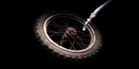 Fototapeta premium Muddy Tire with Water Hose and Spoked Wheel