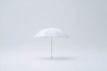 solitary open umbrella representing shelter and protection set against stark white background
