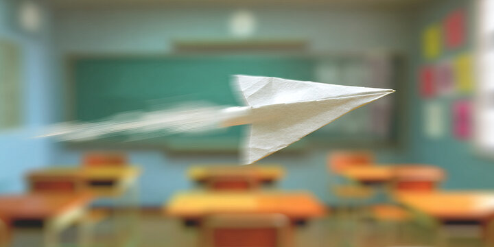 Paper Airplane in Motion over Blurred Classroom