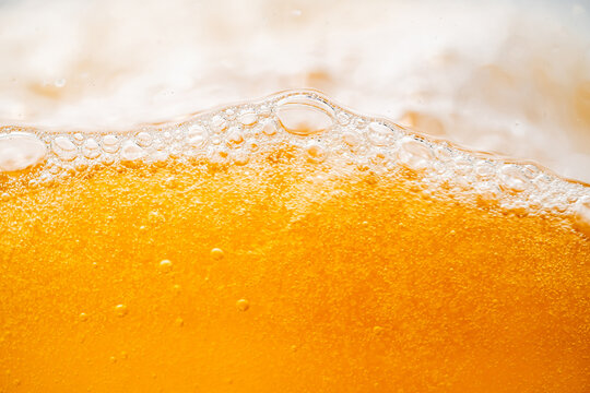 Close up bright orange Oil or beer splash texture and nature waves, Beautiful waves curve and little bubbles smooth for graphic design and background, Oil Bubbles, Soft beer bubbles, Selective focus