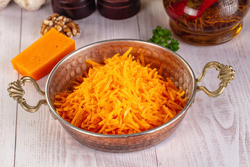 Yellow shredded cheddar cheese in the bowl