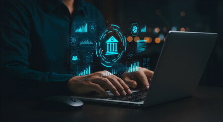 Person Using Laptop with Glowing Digital Finance and Banking Interface Overlaying in Dark Room Setting